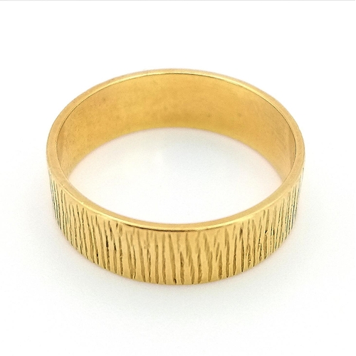 732 - AN 18K GOLD BAND RING WITH PATTERNED EXTERIOR .  3.9gms   size 0