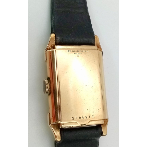 758 - A Vintage Gold Plated Bulova Ladies Tank watch. Black leather strap. Gold plated case - 21mm x 36mm.... 