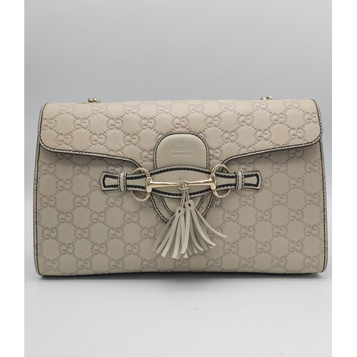 102 - A Gucci Beige 'Emily' Bag. Monogram leather exterior with buckle and tassels. A chunky and heavy set... 