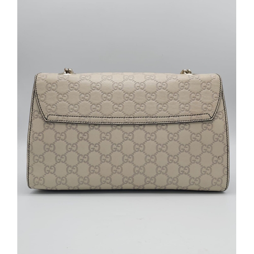 102 - A Gucci Beige 'Emily' Bag. Monogram leather exterior with buckle and tassels. A chunky and heavy set... 