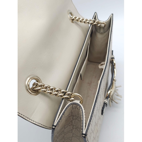 102 - A Gucci Beige 'Emily' Bag. Monogram leather exterior with buckle and tassels. A chunky and heavy set... 