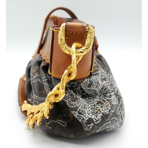 144 - A Louis Vuitton Dentelle 'Kristen' Bag. Monogram leather exterior with intricate lace detailing. Fea... 