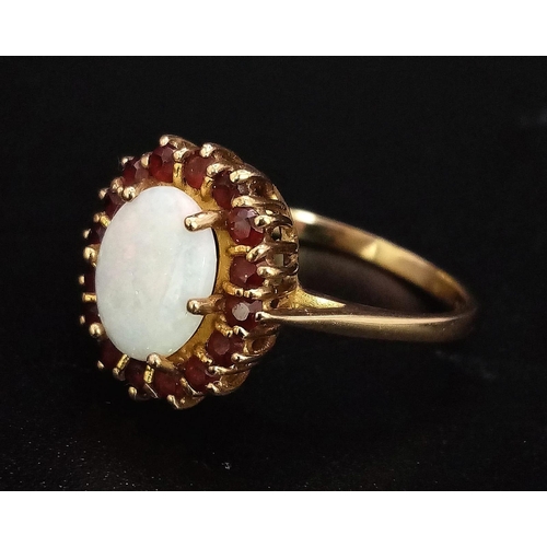 212 - A 9K GOLD RING WITH CENTRAL OPAL WITH RUBY SURROUND . 2.4gms   size Q