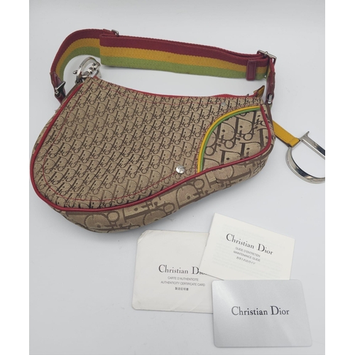 578 - A Christian Dior Rasta Saddle Shoulder Bag. Tan and brown monogram canvas with red piping exterior. ... 