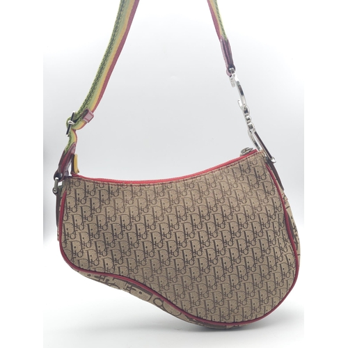 578 - A Christian Dior Rasta Saddle Shoulder Bag. Tan and brown monogram canvas with red piping exterior. ... 