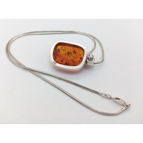 600 - A sterling silver snake chain necklace with a large free shape   amber pendant.  Chain length: 46 cm... 