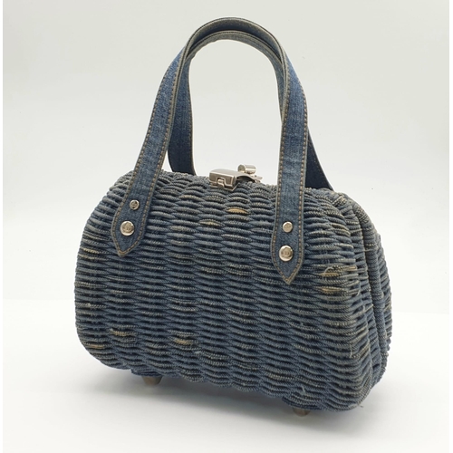 864 - A Christian Dior Denim Handbag. Woven denim exterior with two exterior pockets. Silver-toned metal c... 