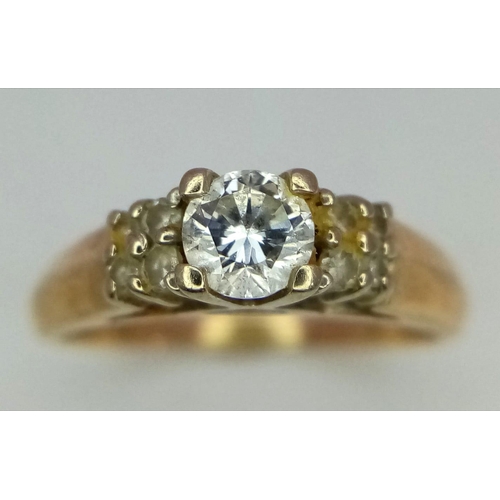 444 - A 14K Yellow Gold Diamond Ring. Brilliant cut central diamond with four small stones either side. Si... 