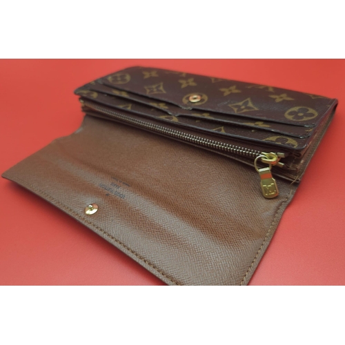 878 - Louis Vuitton Wallet.
Measuring 18.5cm wide, this Louis Vuitton wallet is patterned in the trademark... 