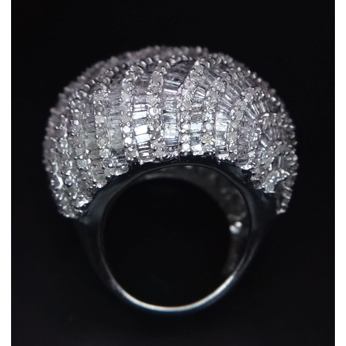 489 - An Ultra Glamourous 18K White Gold Three-Storey Diamond Paved Dress Ring. Baguette and round cut pav... 