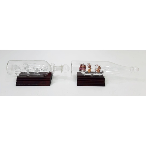 975 - A Pair of Vintage Glass Ships in Bottles of the Bounty & the Santa Maria on Wooden Plinths 23 & 19cm... 