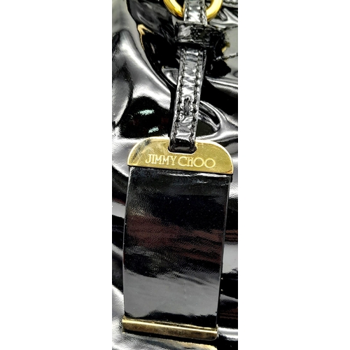 555 - Jimmy Choo Black Patent Leather Handbag.
Gorgeous feel to this handbag. Double strapped, with engrav... 