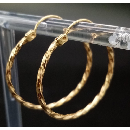 446 - A Pair of 14K Yellow Gold Hoop Earrings. Twist decoration. 25mm diameter. 1.56g weight.