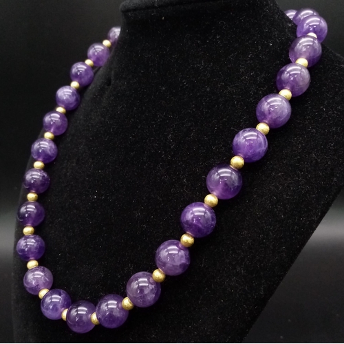 188 - A fashionable, heavily gilded amethyst necklace and earrings set in a presentation case. Very good c... 