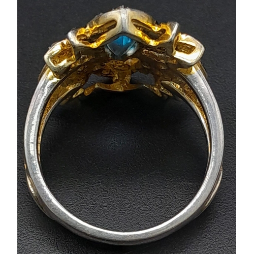 275 - A Gilded Silver Dress Ring with a Marquise Blue Topaz at Centre. Rub-over set topaz with a rose-cut ... 