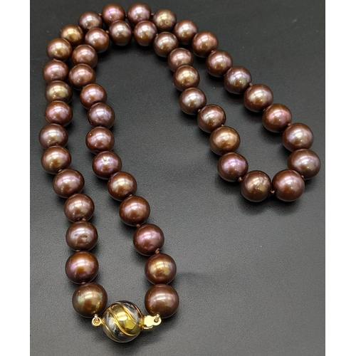 649 - A Purple/Brown Freshwater Pearl Necklace with a 9K yellow and white gold swirl design clasp. 42cm le... 