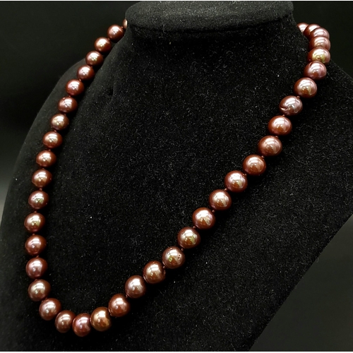 649 - A Purple/Brown Freshwater Pearl Necklace with a 9K yellow and white gold swirl design clasp. 42cm le... 