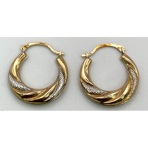 465 - A Pair of White and Yellow Gold Creole Earrings. 0.91g total weight.