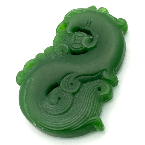 835 - A Chinese Green Jade Swirling Dragon Pendant. 5cm