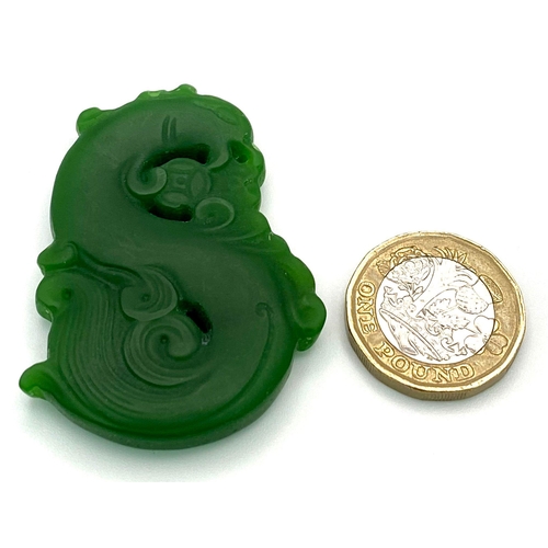 835 - A Chinese Green Jade Swirling Dragon Pendant. 5cm