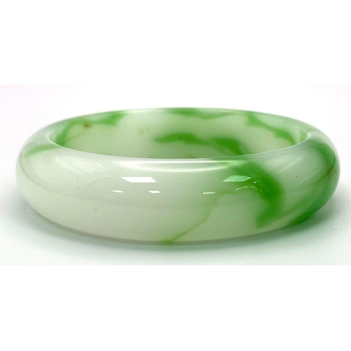 428 - A Green and White Chinese Jade Bangle. 6cm inner diameter.
17mm width.