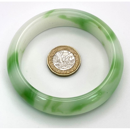 428 - A Green and White Chinese Jade Bangle. 6cm inner diameter.
17mm width.