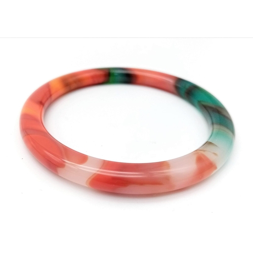 879 - A Multi-Coloured Thin Chinese Jade Bangle. 6cm inner diameter. 8mm width.