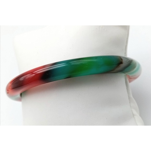 879 - A Multi-Coloured Thin Chinese Jade Bangle. 6cm inner diameter. 8mm width.