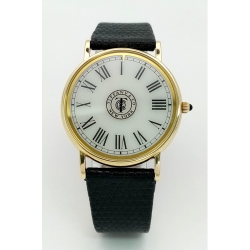 925 - A Vintage 14K Gold Cased Tiffany and Co Ladies 'No Hands' Watch. Black leather strap. 14k gold case ... 