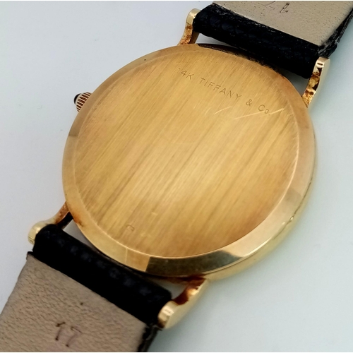 925 - A Vintage 14K Gold Cased Tiffany and Co Ladies 'No Hands' Watch. Black leather strap. 14k gold case ... 