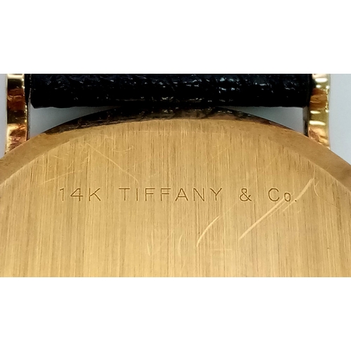 925 - A Vintage 14K Gold Cased Tiffany and Co Ladies 'No Hands' Watch. Black leather strap. 14k gold case ... 