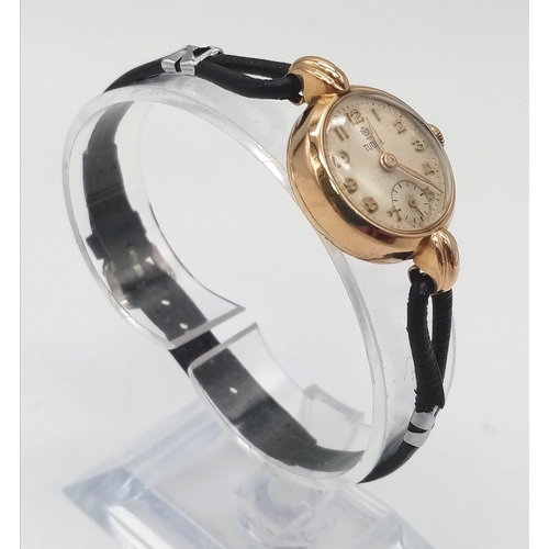 239 - A Vintage (1950s) 9K Gold Tudor Ladies Watch. Black leather strap. 9K gold case - 22mm. White dial w... 