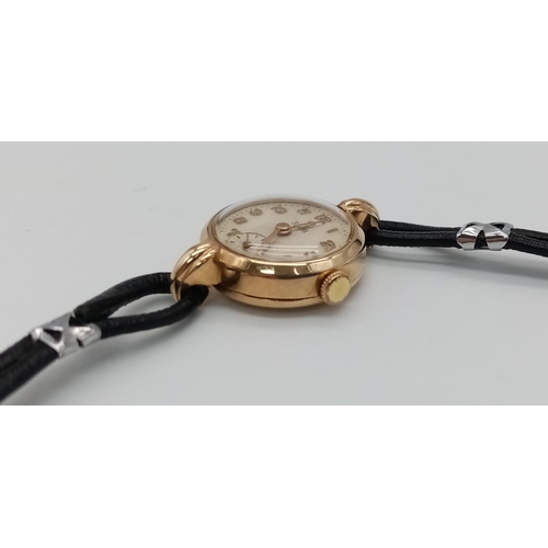 239 - A Vintage (1950s) 9K Gold Tudor Ladies Watch. Black leather strap. 9K gold case - 22mm. White dial w... 