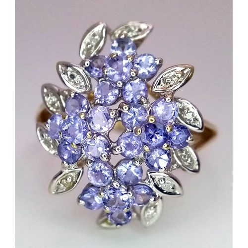 509 - A 9K Yellow Gold Tanzanite and Diamond Floral Statement Ring. Size R. 0.12ctw diamonds, 1.20ctw tanz... 