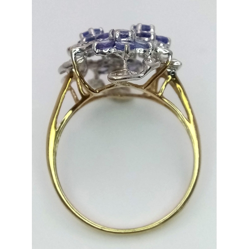 509 - A 9K Yellow Gold Tanzanite and Diamond Floral Statement Ring. Size R. 0.12ctw diamonds, 1.20ctw tanz... 