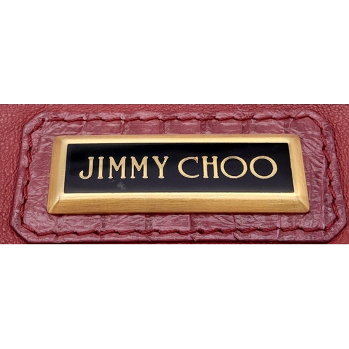 711 - A Jimmy Choo Magenta Bag. Leather exterior with gold-tone hardware and chain strap. Canvas interior,... 