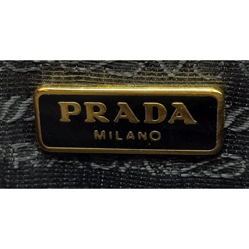 304 - A Prada Black Perforated Satchel Bag. Saffiano fori leather exterior, with an open top, two rolled h... 