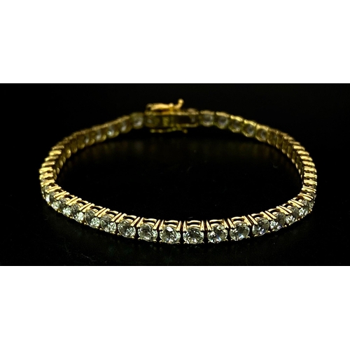 681 - A STUNNING 14K GOLD TENNIS BRACELET WITH BRIGHT SPARKLING ZIRCONIA STONES.   9.8gms