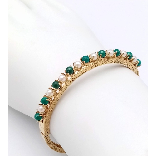 492 - A 14K GOLD HINGED BANGLE DECORATED WITH JADE AND SEED PEARLS WITH OPEN WORK BACK HALF AND NICELY HAN... 