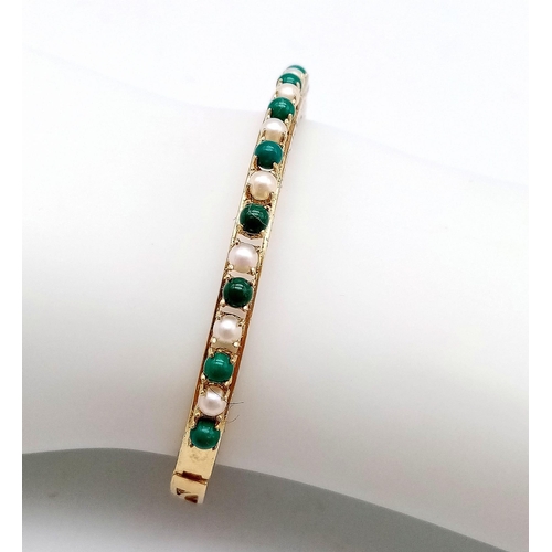 492 - A 14K GOLD HINGED BANGLE DECORATED WITH JADE AND SEED PEARLS WITH OPEN WORK BACK HALF AND NICELY HAN... 