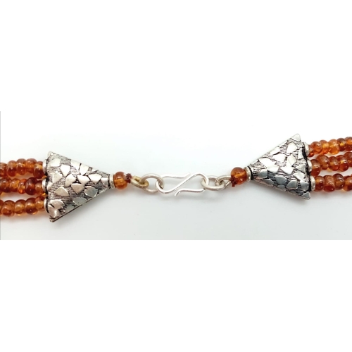 555 - A Three Row Hessonite Garnet Small Rondelle Bead Necklace. 245ctw. 925 Silver Clasp. 40-46cm length.