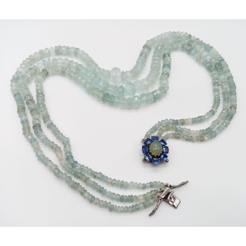 618 - An Aquamarine Three Strand Graduated Bead Necklace. Opal and Kyanite Halo Clasp. Aquamarines - 422ct... 