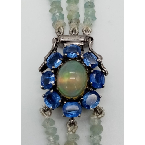 618 - An Aquamarine Three Strand Graduated Bead Necklace. Opal and Kyanite Halo Clasp. Aquamarines - 422ct... 