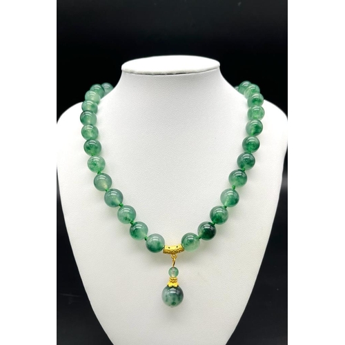 953 - A Green and White Jade Bead Necklace with Hanging Pendant. Gilded accents and clasp. Beads 12mm/14mm... 