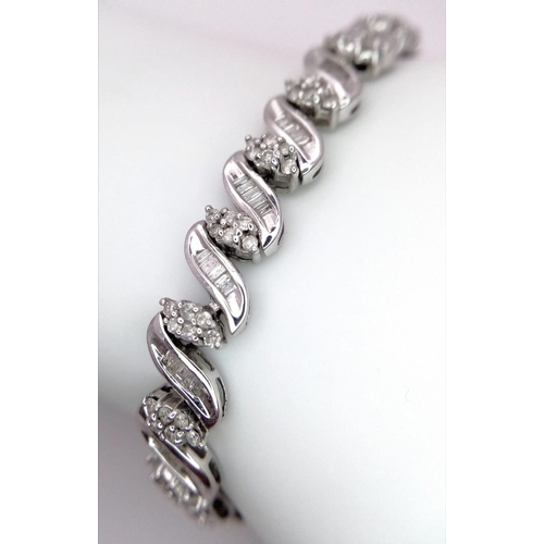 13 - A 14K WHITE GOLD DIAMOND SWIRL BRACELET. A COMBINATION OF BAGUETTE AND ROUND CUT DIAMONDS 2.30CT 15.... 