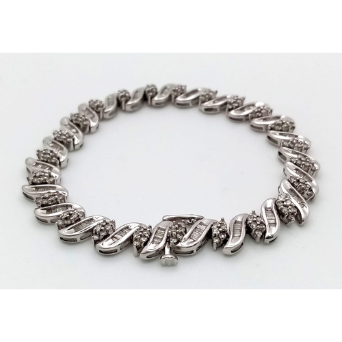 13 - A 14K WHITE GOLD DIAMOND SWIRL BRACELET. A COMBINATION OF BAGUETTE AND ROUND CUT DIAMONDS 2.30CT 15.... 