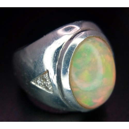 581 - A Large Opal and Diamond Dress Ring. Beautiful oval opal cabochon with superb colour play and three ... 