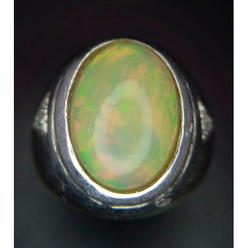 581 - A Large Opal and Diamond Dress Ring. Beautiful oval opal cabochon with superb colour play and three ... 