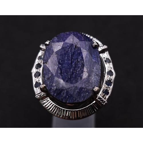 584 - A Blue Sapphire and 925 Silver Ring. Oval cut central sapphire with small sapphire accents. Size R. ... 