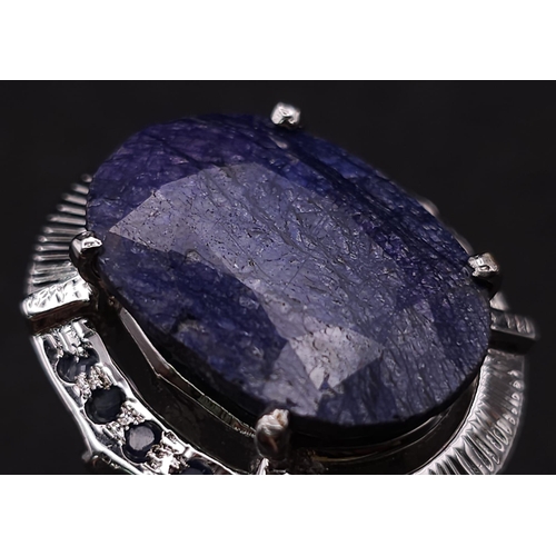 584 - A Blue Sapphire and 925 Silver Ring. Oval cut central sapphire with small sapphire accents. Size R. ... 